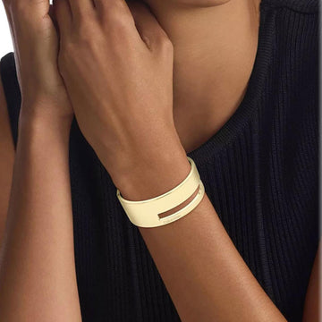 Γυναικεία χειροπέδα Calvin Klein 35000673 σε χρυσό χρώμα από ανοξείδωτο ατσάλι με στοιχεία από το λογότυπο της εταιρίας, φορεμένη